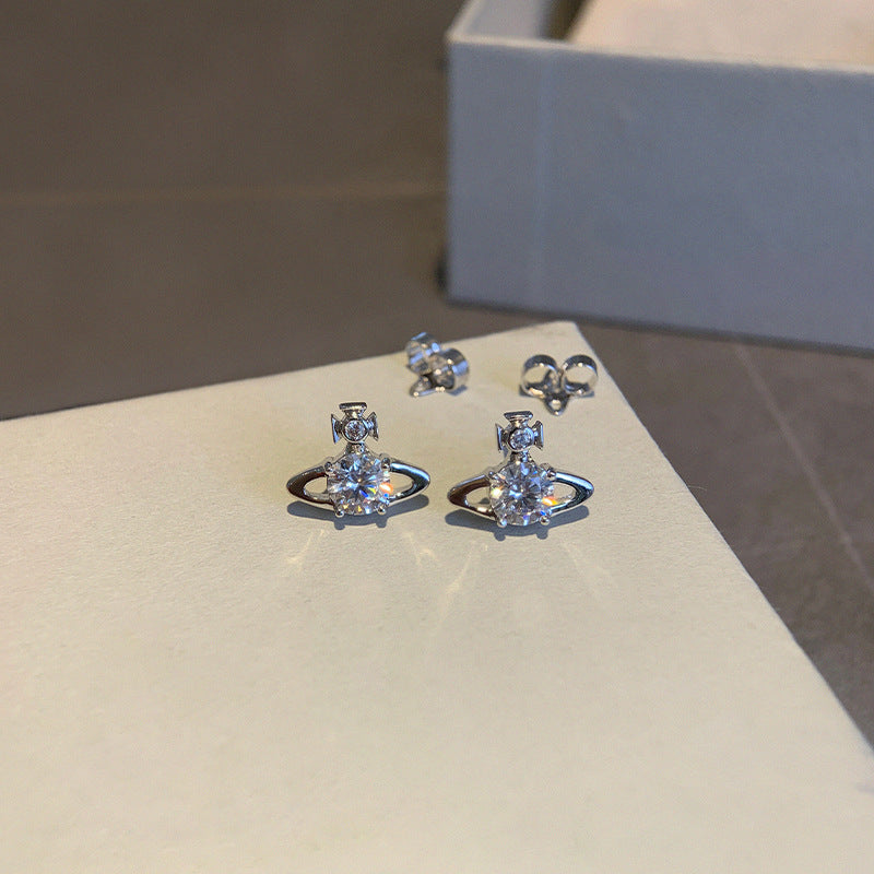 The new Queen Mother Reyna Saturn Stud Earrings are classic shiny solitaire star sparkle minimalist commuter style earrings